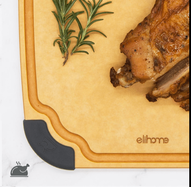 Close-up of an Elihome wood fiber cutting board with color-coded gray silicone corner for poultry, featuring deep juice groove, shown with roasted chicken and rosemary