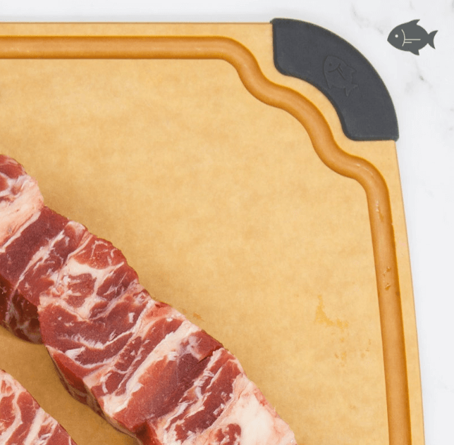 Close-up of an Elihome wood fiber cutting board with color-coded gray silicone corner for fish and seafood, featuring deep juice groove, shown with raw pork ribs