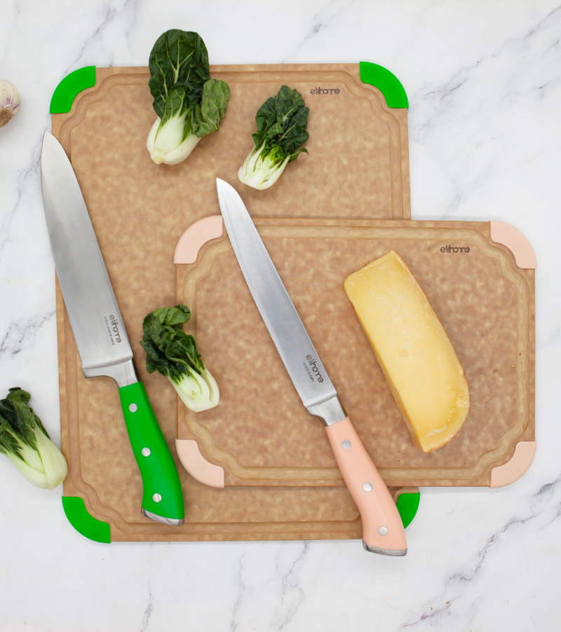 Two cutting boards with knives and vegetables on a marble surface