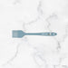 Green spatula with 'elihome' branding on a marble background