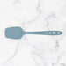 Blue spatula with a brand logo on a marble background