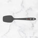 Black spatula with a brand logo on a marble background