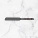 Black spatula with brand logo on a marble background