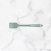 Green spatula with 'elihome' branding on a marble background