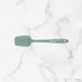 Green spatula on a marble background
