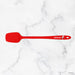 Red spatula with a brand logo on a white marble background