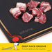 Raw meat on a black cutting board with 'elihome' branding, featuring a deep juice groove.