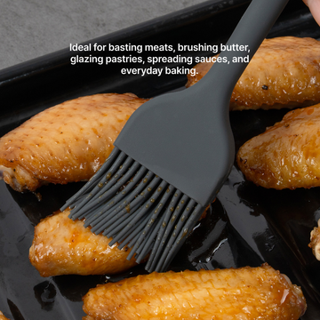 Elihome x Peanuts Silicone Basting Brush glazing baked chicken wings on a sheet pan, ideal for basting meats, brushing butter, glazing pastries, spreading sauces and everyday baking