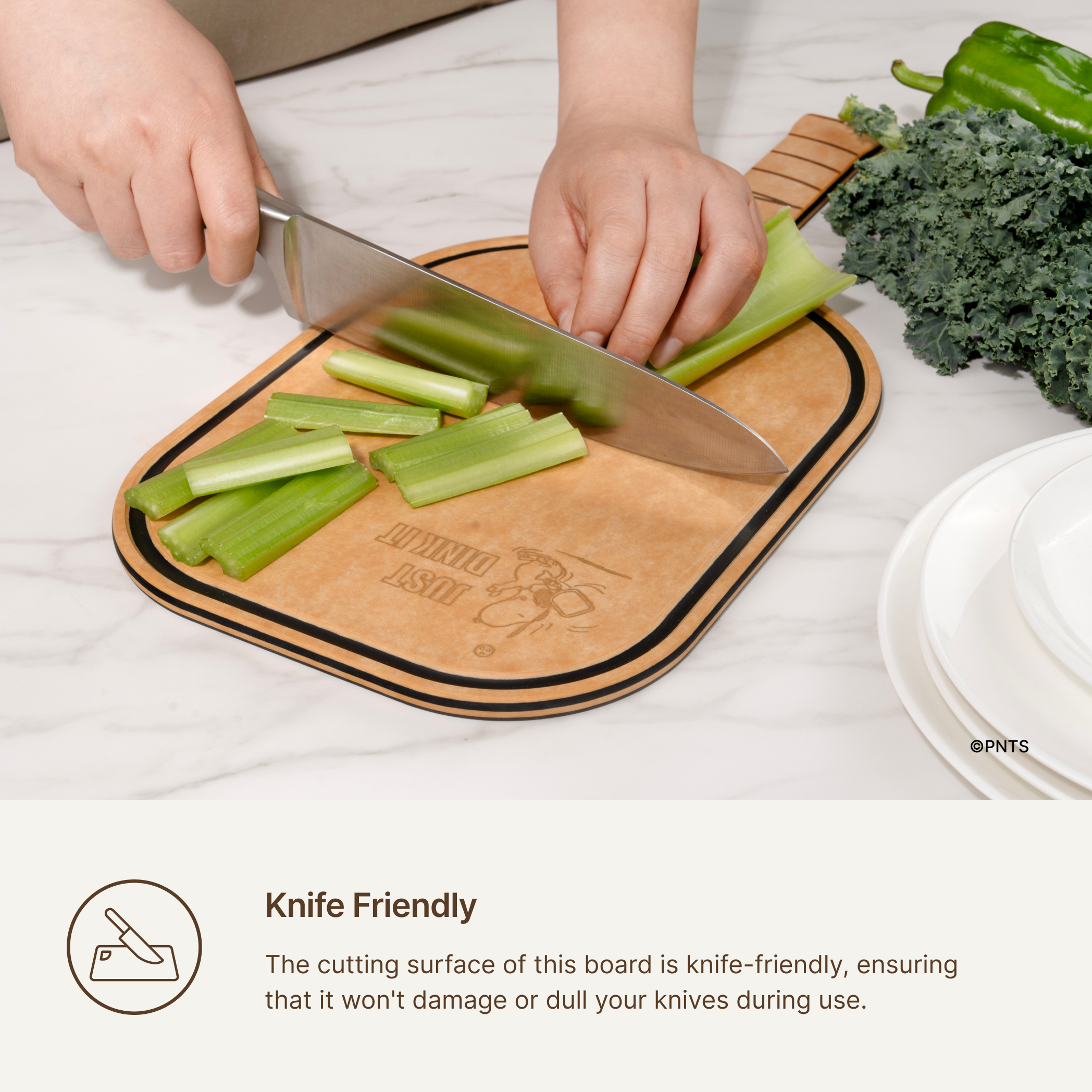 Knife slicing celery on an Elihome x Peanuts pickleball paddle board, knife-friendly surface that will not dull your knives