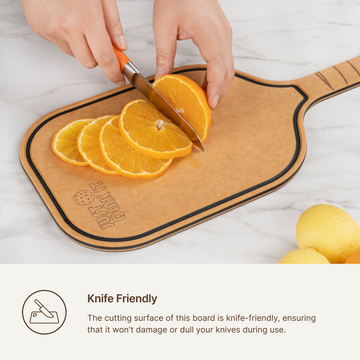 Orange slices being cut on an Elihome pickleball paddle cutting board, knife-friendly surface that will not dull blades