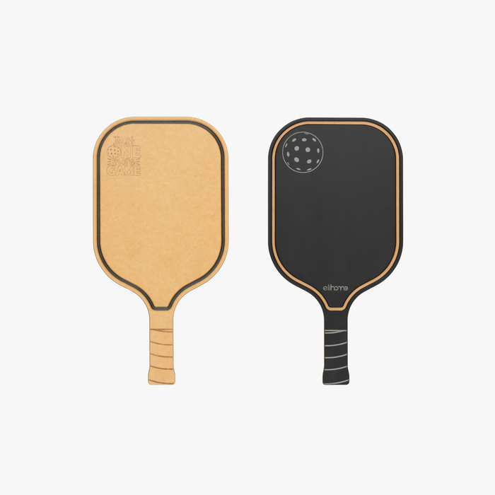 Elihome pickleball paddle cutting board shown from both sides, natural wood fiber engraved with Just One More Game and a reversible black serving side